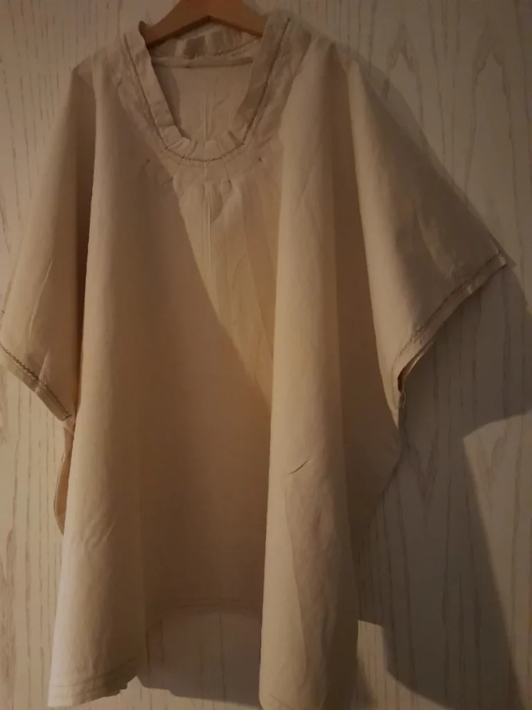 une tunique large en lin naturel avec le col et les manches ornées d'un point décoratif en fil vert lime