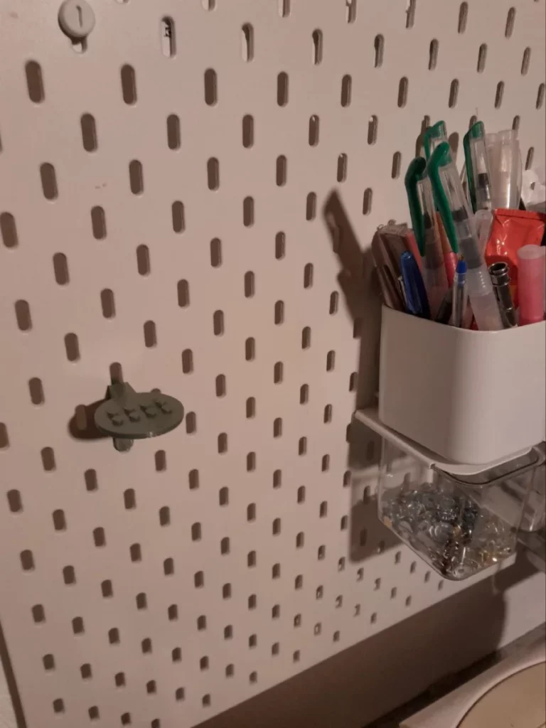 le support suspendu tout seul. On y apperçoit, sur un disque, deux rangées de quatre pegs aux dimensions lego
