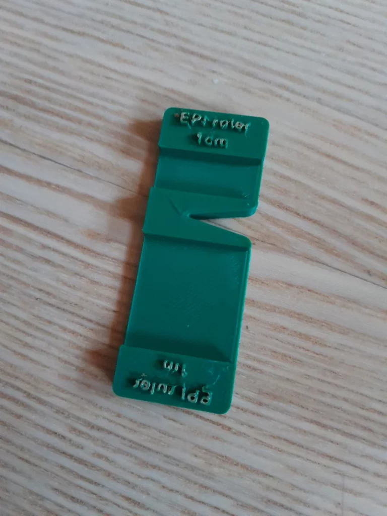 La réglette nue, avec une zone de 1 inch et une zone de 1cm, puis une encoche au milieu pour y coincer le fil