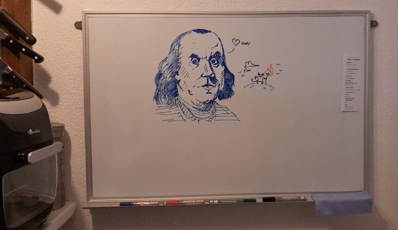 sur un tableau blanc dans la cuisine, un dessin au marker de Benjamin Franklin qui dit "uwu"