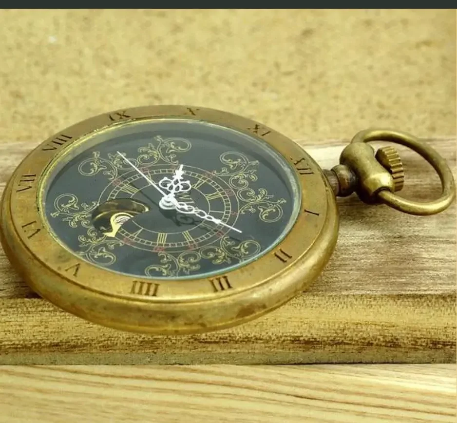 Cette montre à gousset d'aspect bronze se distingue des autres par la simplicité de son design et le fait qu'on ne peut pas voir son mouvement. Très plate, son boîtier présente des arrêtes droites. Le capot à l'avant est gravé de chiffres romains pour indiquer les heures. Le cadran ne porte aucune inscription, simplement quelques arabesques dorées sur un fond qui semble bleu marine.