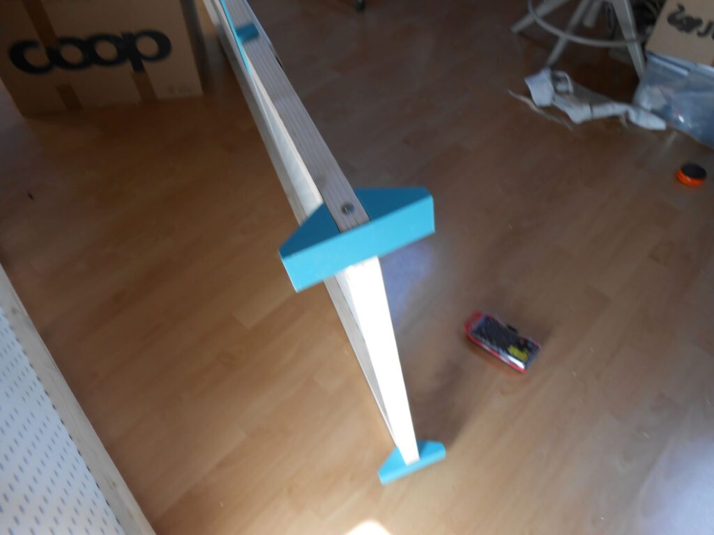 le pied-équerre vu de face, dans lequel le cadre est parfaitement serti. 