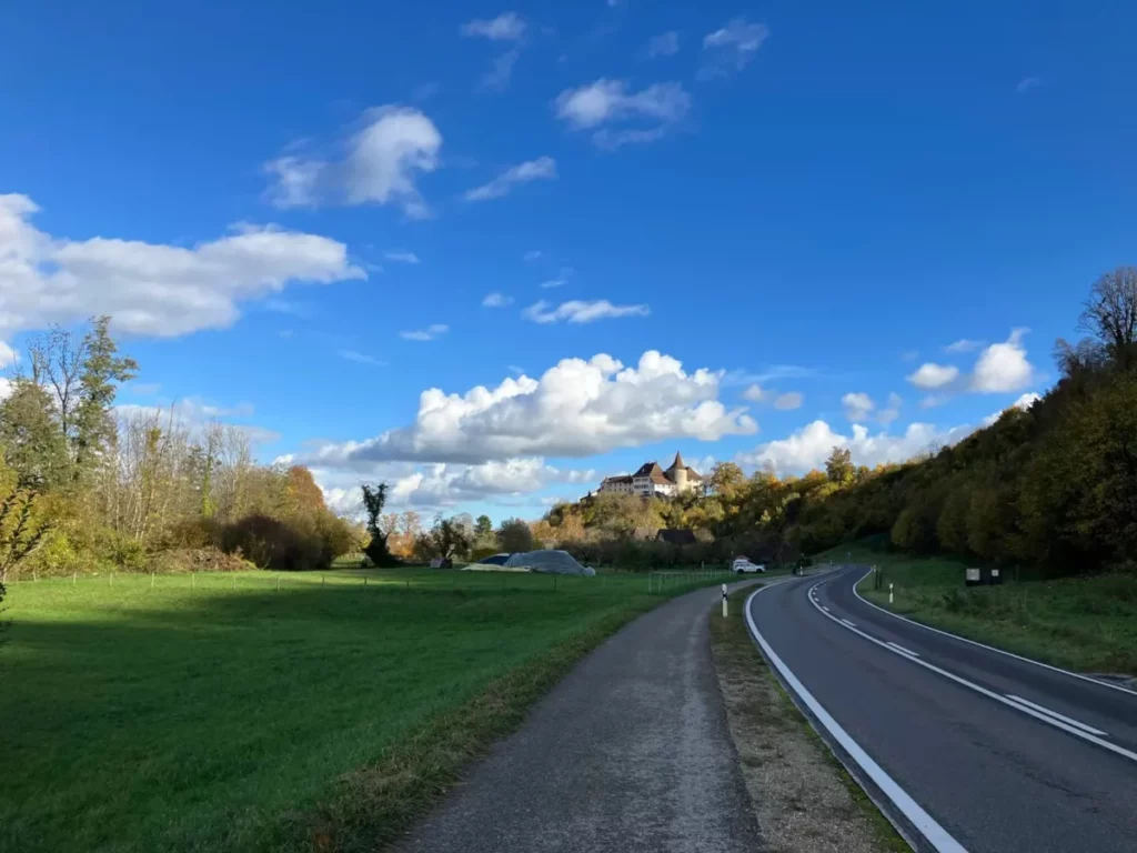le côté sud du lac est quasi intégralement longé de pistes cyclables de ce genre, protégées de la route, fraichement goudronnées et très agréables. Dans le fond on apperçoit un bâtiment qui ressemble à un petit château. Toute la région a des airs très médiévaux.