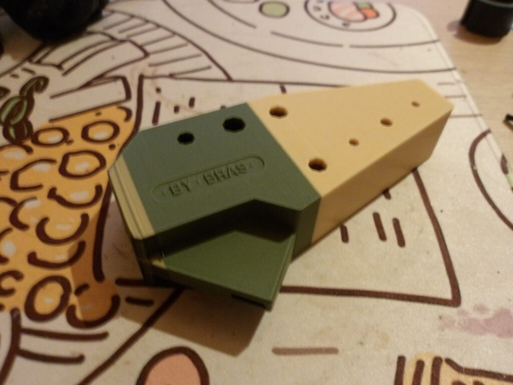 Un ocarina tout cubique. Il a une toute petite bande gris orangé dégueulasse à la base, puis il se divise presque au milieu entre du vert kaki et du beige